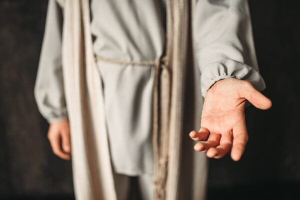 Man in the image of Christ reaching out his hand